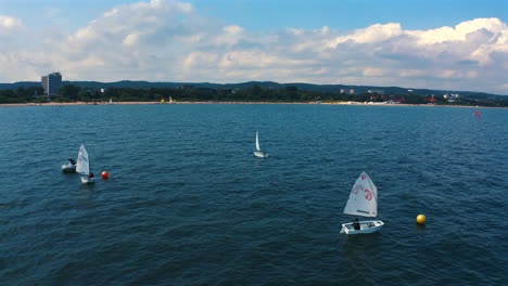 panoramablick auf optimistische dungen, die an einem sonnigen urlaubstag in der nähe der stadt sopot auf der ostsee segeln