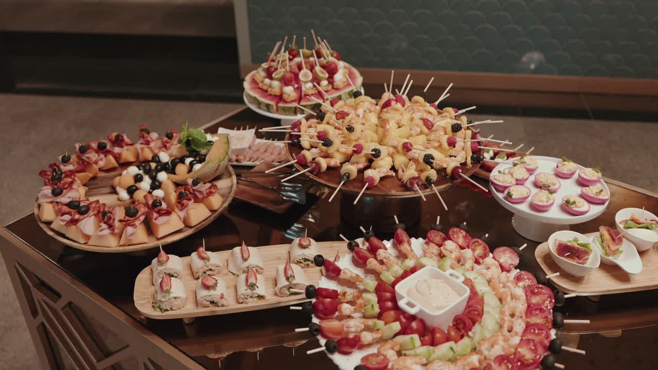 뷔페 테이블에 다채로운 애피타이저와 꼬치가 화려하게 진열되어 있어요.