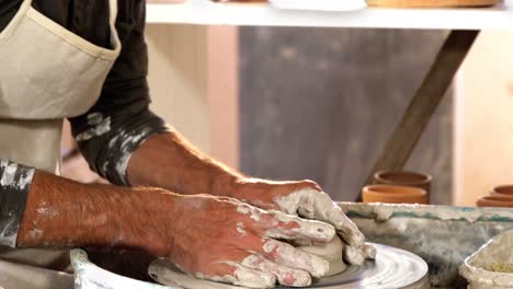 hombre alfarero haciendo ollas en taller de cerámica