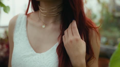 드레스를 입은 젊은 여성이 빨간 머리카락을 만지는 영화적 트 다운 비디오