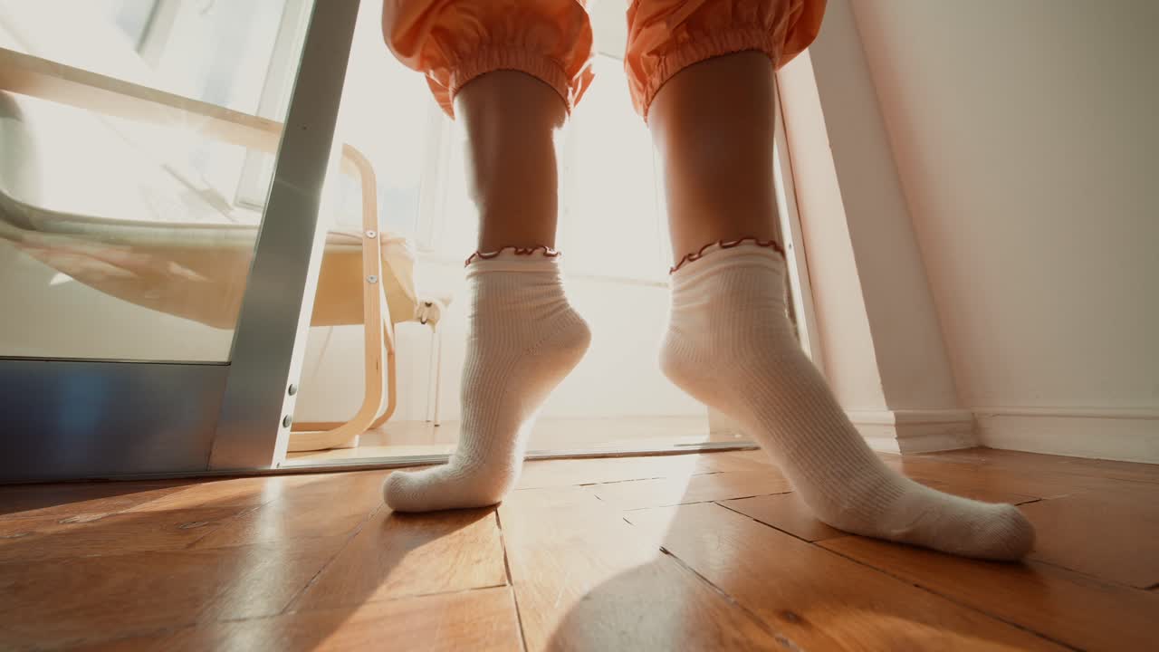A person wearing socks standing on a wood floor