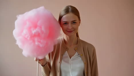 person holding pink cotton candy in front of face