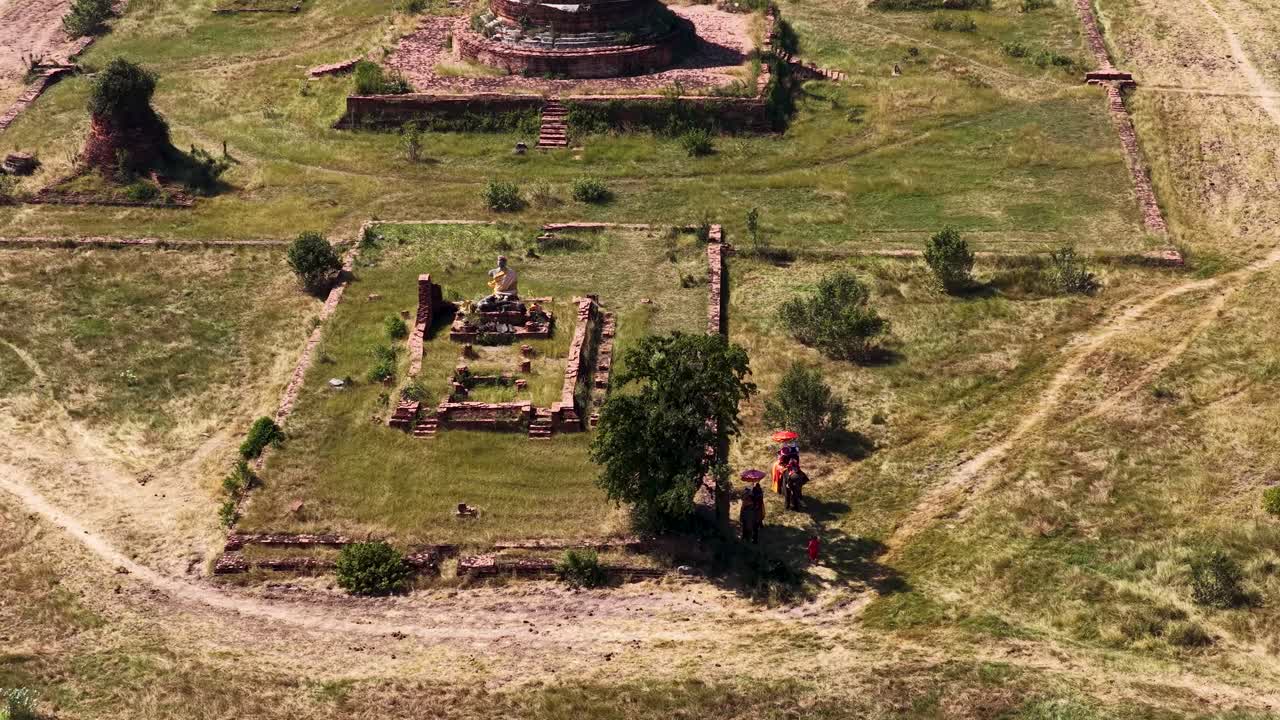 Ripresa aerea con drone di antiche rovine di mattoni e stupa sotto la luce del sole ad Ayutthaya, Thailandia