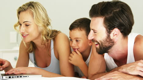 happy family smiling and looking a laptop