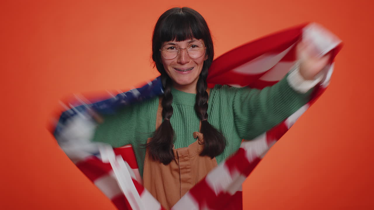 젊은 괴짜 여성이 미국 국기를 흔들고 포장하고, 축하하고, 인권과 자유를 축하하고