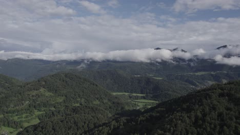 Reverse-plane-drone-video-flying-over-the-Triglav-mountains-in-the-Bohinj-area-in-Slovenia-with-a-clear-sky-with-clouds