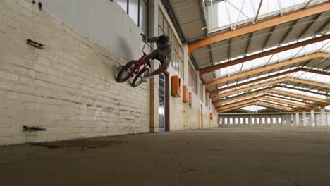 bmx riders in an empty warehouse riding on wall