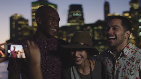 Group-Of-Friends-Posing-For-Photo-In-Front-Of-Manhattan-Skyline-At-Dusk