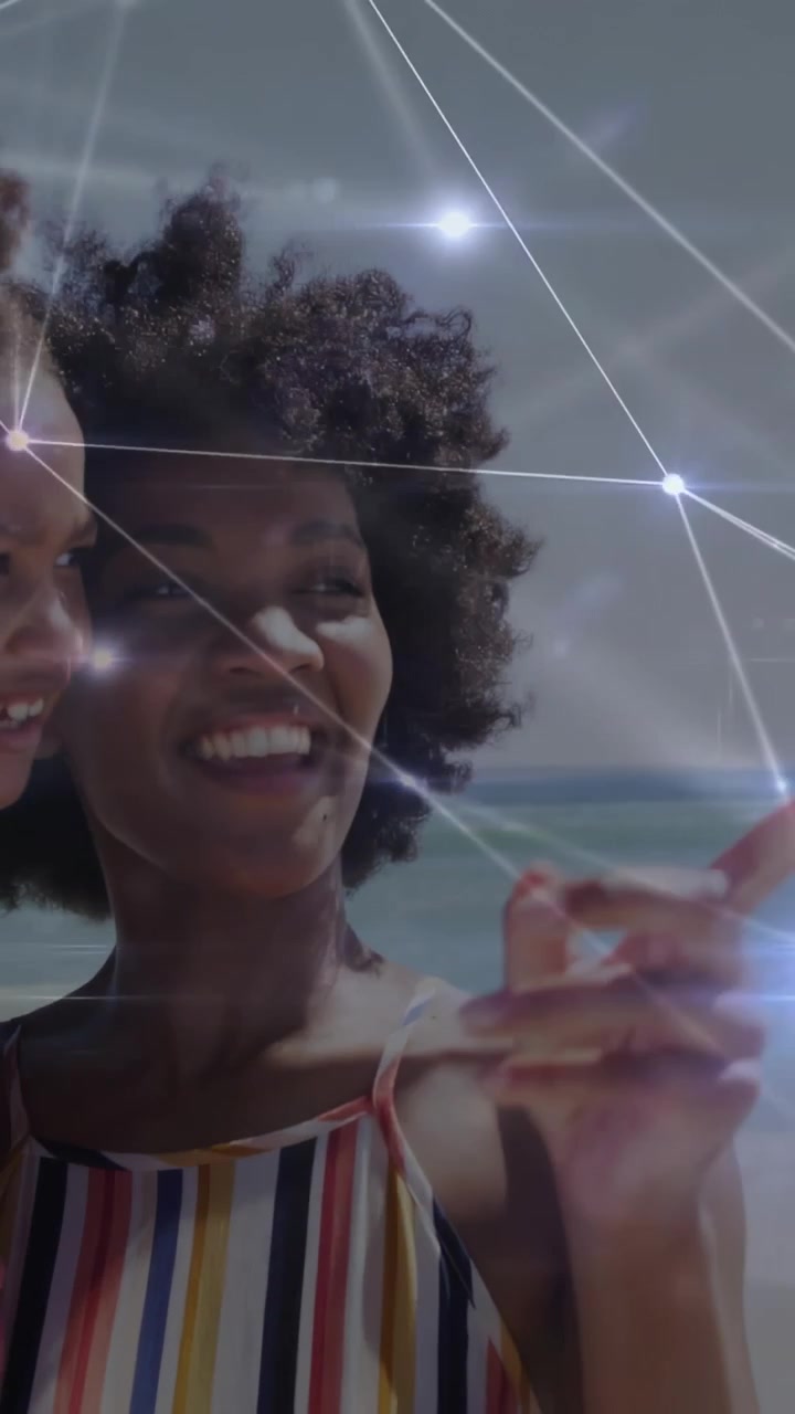 Vertical video: Mom holding kid pointing to ocean, watching as spark overlay linking faces for ads