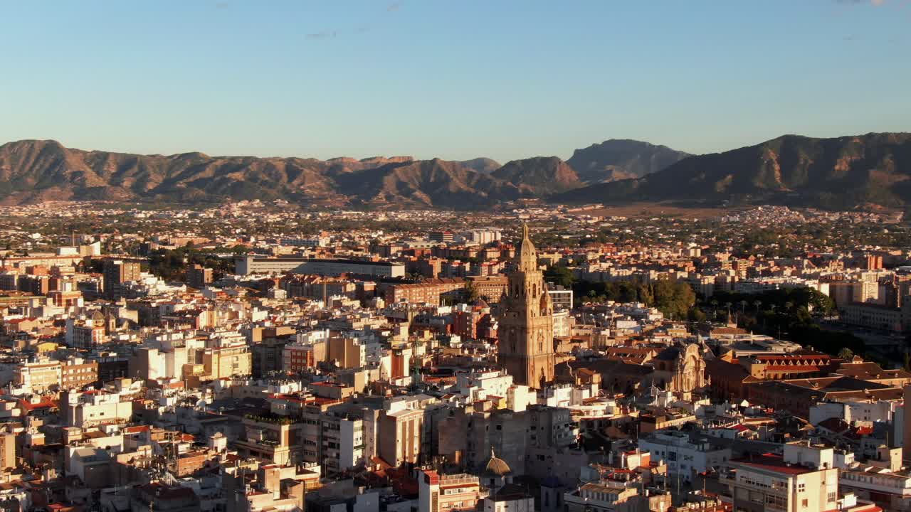 tiro de drones orbitando la catedral de murcia en españa al atardecer
