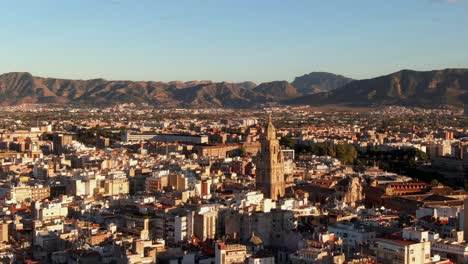 drone shot orbiting the cathedral of murcia in spain at sunset