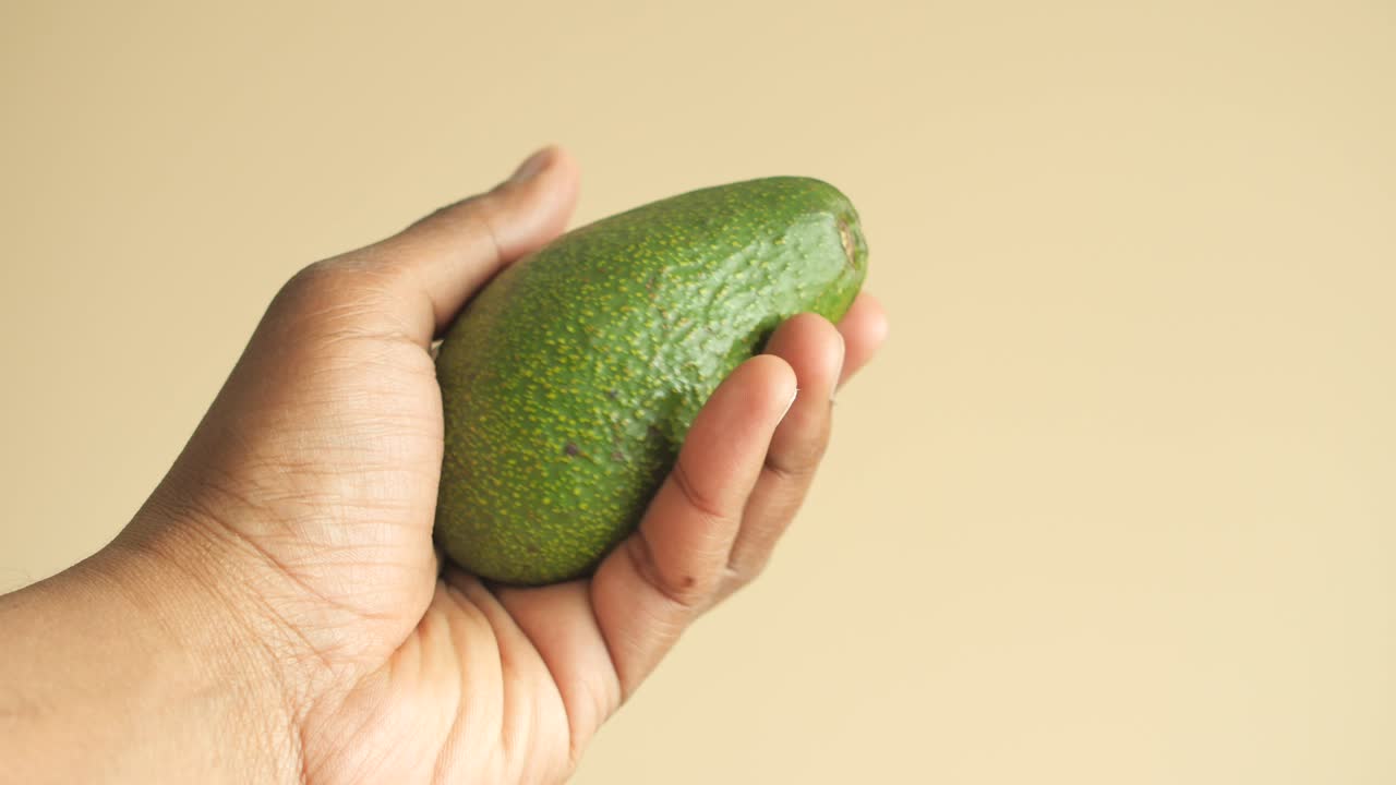 Mano che tiene un avocado