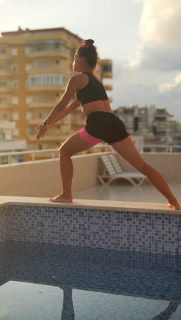 woman practicing yoga outdoors by the pool