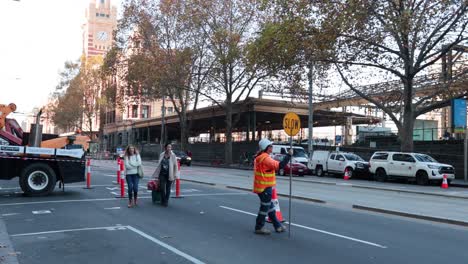 trabajador que dirige a los peatones y a los vehículos