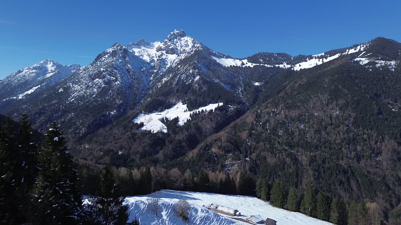 vista aérea de drones volando más allá de bancos en el punto de vista en los alpes austriacos, vista sobre el paisaje montañoso cubierto de nieve con bosque de pinos