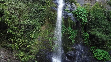 antena de drones moviéndose hacia una cascada verde tropical en la selva tropical