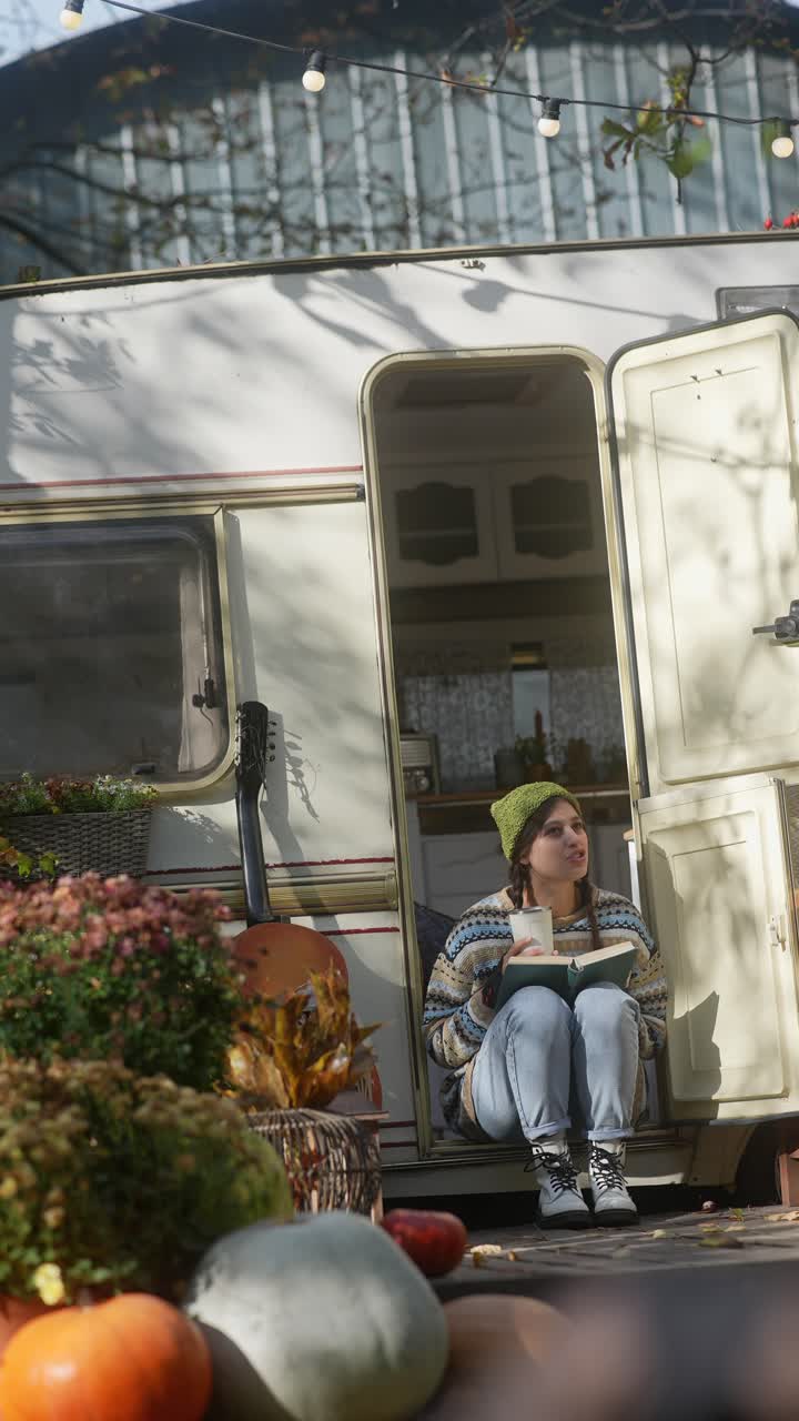 Donna che si rilassa con un libro in una roulotte