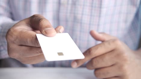 persona con una tarjeta de crédito blanca