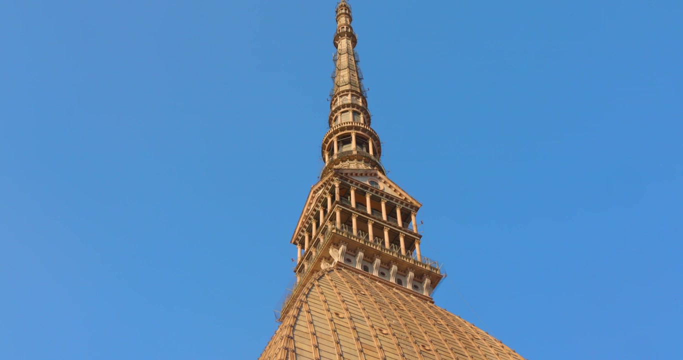 Guardando verso l'alto il dettaglio intricato della guglia neoclassica della Mole Antonelliana, Museo Nazionale del Cinema, che si innalza in un cielo azzurro e limpido in una giornata di sole, Torino, Piemonte, Italia