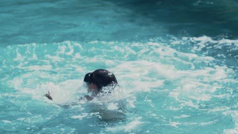 niño feliz con gafas saltando a la piscina en un cálido día de verano