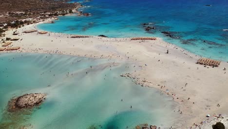 Toma-Aérea-De-Estas-Aguas-Azules-Y-Turquesas-De-La-Playa-De-Arena-Blanca-Elafonissi-En-Creta,-Grecia