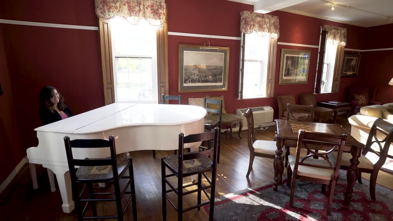 Interior of a room with a white piano and dining table