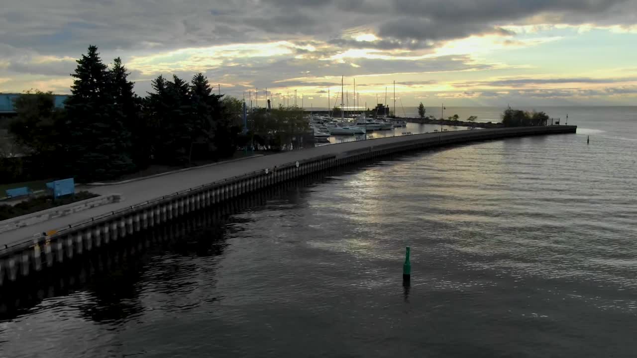 drone elevándose sobre el puerto de mississauga con un amanecer sobre el lago ontario