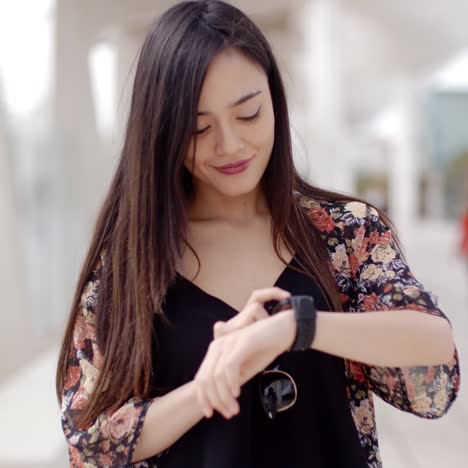 Young-woman-looking-at-the-time-with-a-smile