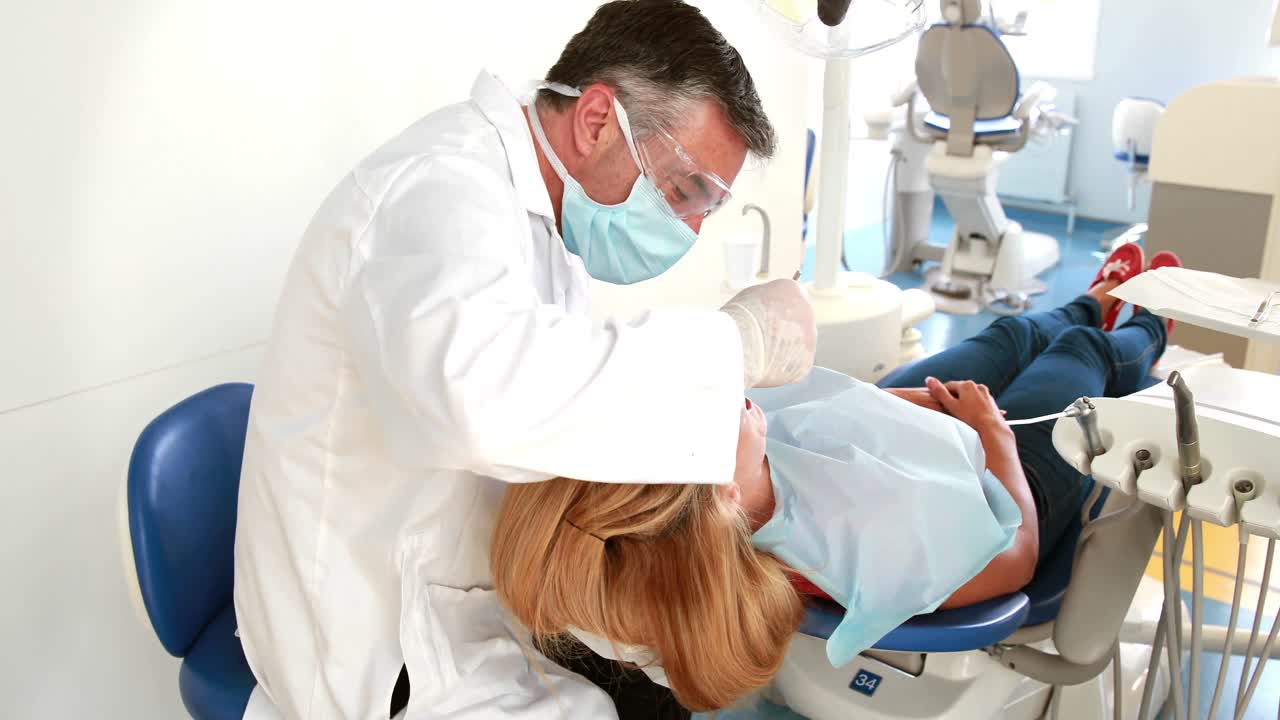 Dentista examinando los dientes de una mujer.