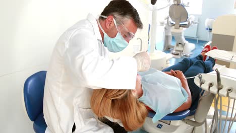 un dentista examinando los dientes de una mujer.