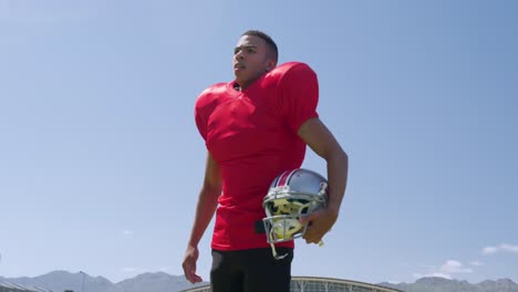 American-football-player-standing-with-helmet