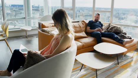 couple using digital tablet and mobile phone in living room 4k