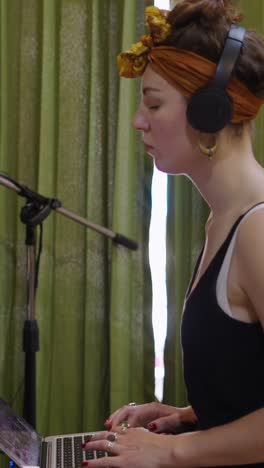 woman with headphones in recording studio