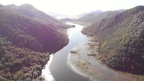 an aerial view of lake skadar in montenegro on the bend of the river during a beautiful sunny day