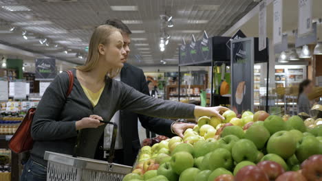 young people choosing apples in the supermarket