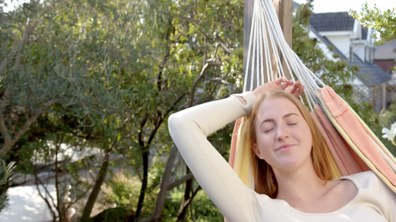 Relaxing in hammock, woman enjoying sunny day outdoors in backyard
