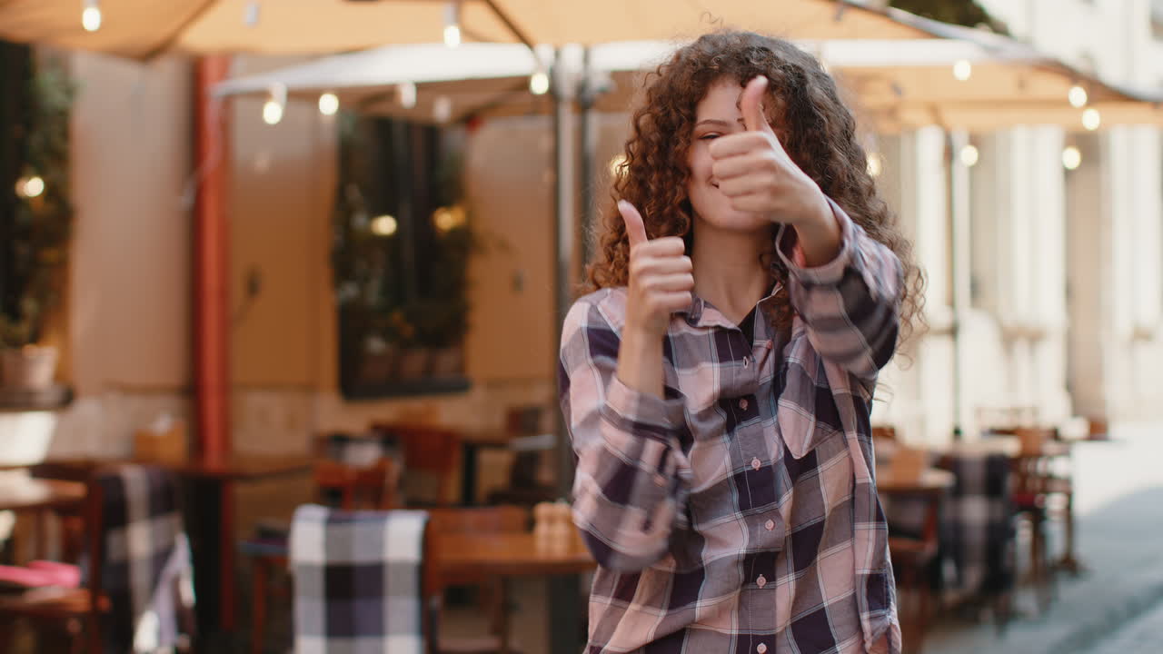 mujer feliz mostrando los pulgares hacia arriba como señal positiva algo bueno retroalimentación positiva en la calle de la ciudad