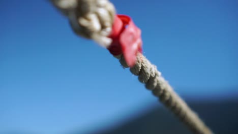 SLOWMO---Detail-of-nautical-rope-with-sky-and-scenery-in-background