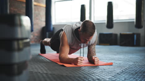gimnasio, tabla y un hombre en el suelo para hacer ejercicio