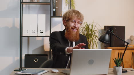 young business man sitting at office workplace desk closing laptop pc after finishing remote work