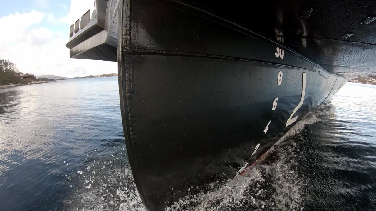 Unique view of ships bow cruising through water - Camera shifting left to right and revealing bow and hull