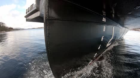 unique view of ships bow cruising through water - camera shifting left to right and revealing bow and hull