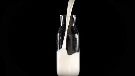 milk being poured into glass bottles