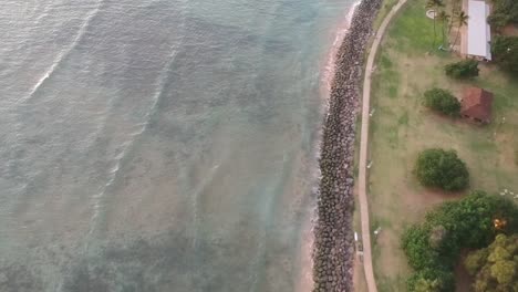 AERIAL-VIEW-DRONE-FOOTAGE-OF-THE-SURF-OFF-THE-COAST-IN-KIHEI-MAUI-HAWAII-TRAVELING-NORTH-TOWARDS-KALAMA-SKATE-PARK-DURING-DUSK-IN-1080