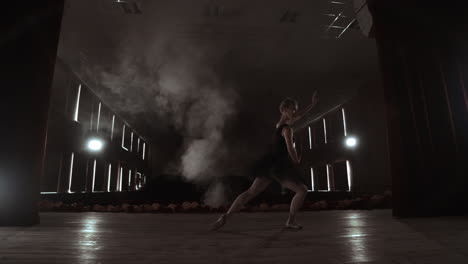 slow motion: prima ballet on stage rehearsing performance in the dark light of the contra. the lights from the hall