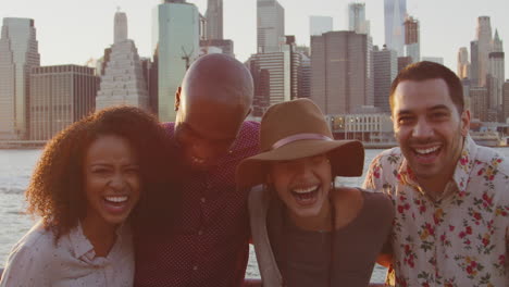 portrait of friends in front of manhattan skyline at sunset