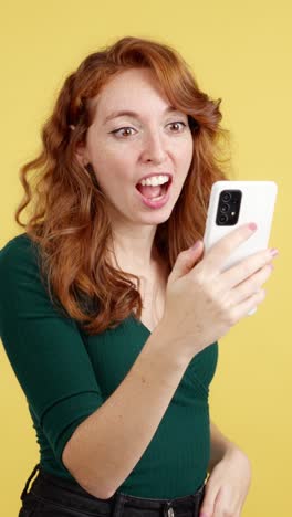 surprised redhead woman reacting to smartphone content