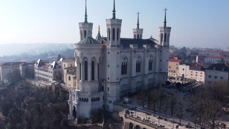 beautiful aerial orbit view of the basilica notre dame de fourvière and metallic tower overlooking lyon city, sunny day