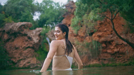 wet hair girl attracting hand posing at tropical nature. woman looking camera