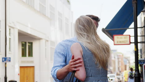 businessman and businesswoman greeting each other on street